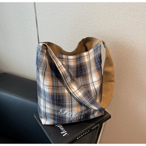 Gros plan d'un sac cabas en toile à carreaux avec imprimé sur un canapé décontracté