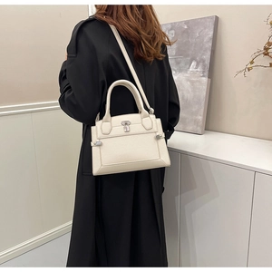 Side view of white lychee leather bag with silver padlock detail on a female model