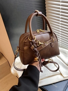 Sac Boston vintage marron avec poignées et détail de pendentif cloche dorée