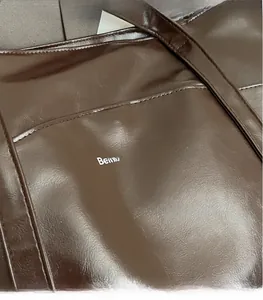 Close-up of brown faux leather tote bag featuring Believe in Yourself print