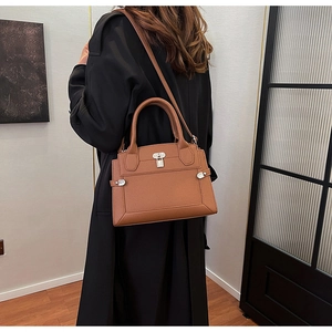Brown lychee leather handbag with silver lock shown in a stylish lifestyle setting