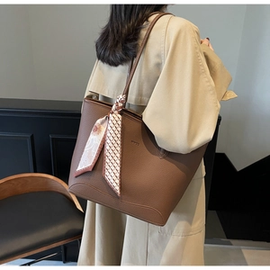 Brown litchi grain leather tote bag with printed silk scarf shown on model shoulder