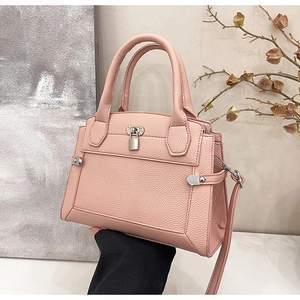 Detail of silver clasp and pebble grain texture on light pink elegant tote bag