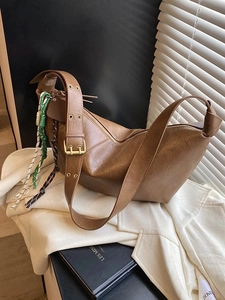 Vintage brown leather crescent bag with adjustable wide strap and colorful rope detail