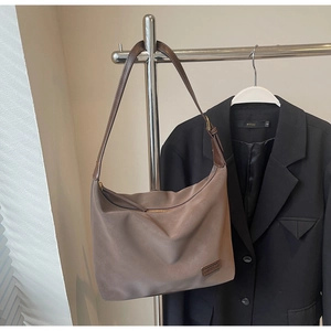 Close-up of the smooth zipper closure and premium suede texture on a brown hobo bag