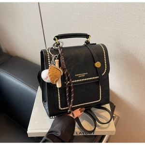 Detail view of black faux leather backpack with vintage rivets and sports charm