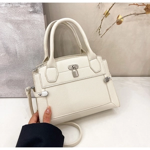 Detailed macro view of high-quality lychee grain leather and silver lock on handbag
