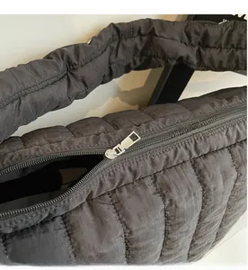 Detailed close-up showing the smooth silver metal zipper and black quilted fabric texture