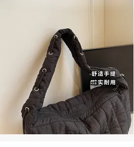 Detail of black quilted cloud bag with padded puffer texture and rope handle silver eyelet
