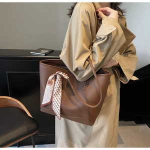 Detail of dark brown lychee leather tote bag with stylish decorative floral silk scarf