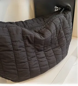 Detail of black quilted puffer bag showing soft pleated texture and secure zipper closure
