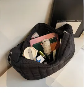Interior view of large capacity black quilted tote bag showing tablet and daily essentials