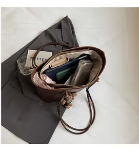 Vue intérieure du sac cabas marron montrant la doublure spacieuse et les poches de rangement