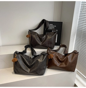Trois sacs hobo en gris, noir et marron avec pendentifs ours en peluche sur marches blanches