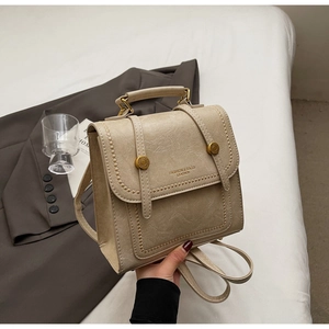 Macro detail of beige mini backpack with gold buckles and fashion leather logo