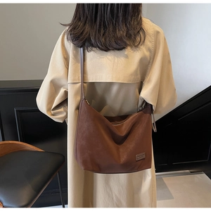 Brown suede hobo bag shown from a back perspective on a model for a casual commute look