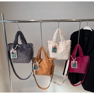 Close-up of four plush tote bags in grey, brown, beige, and pink with cute calculator tags