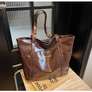 Detail view of large brown faux leather tote bag with Believe in Yourself print