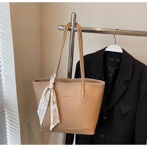 Detail view of khaki tote bag with lychee leather texture and silk scarf decoration