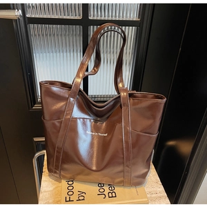 Detailed view of dark brown faux leather tote bag with Believe in Yourself print