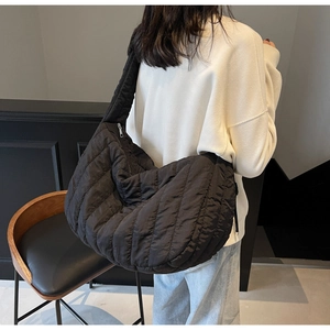 Detail of the black quilted shoulder bag showcasing its lightweight fabric and textured pattern