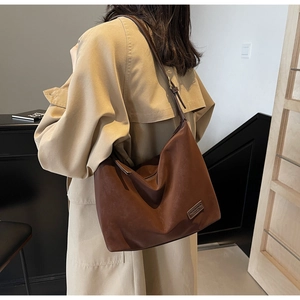 Side view of large dark brown suede hobo bag with adjustable strap for daily commute