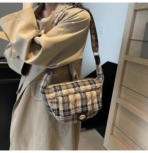 Close-up of vintage plaid shoulder bag with diamond quilting and golden swivel lock