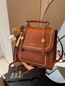 Vintage brown leather backpack for women with baseball charm and fashion gold logo