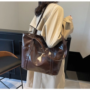 Close-up of deep brown glossy tote bag with Believe in Yourself white text design