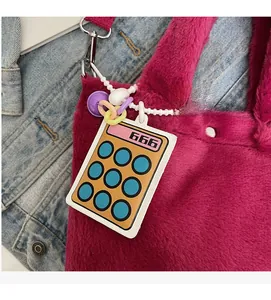Close-up of calculator bag charm with beads on fuchsia plush bucket bag detail