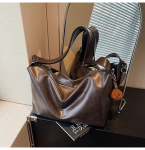 Détail du sac cabas marron vintage avec bandoulière large, fermeture éclair et ours