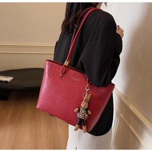 Détail du grand sac cabas rouge texturé avec lettres dorées et pendentif lapin