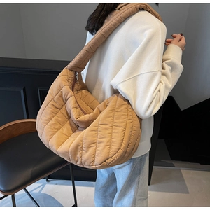 Rear view of a camel large quilted puffer tote bag with thick padded shoulder strap