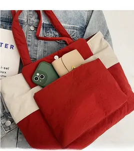 Close-up of color-block tote bag featuring red pockets and large storage capacity