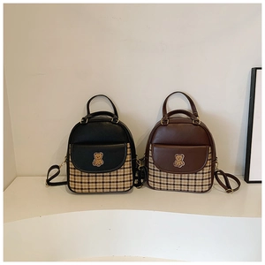 Front view of black and brown plaid patchwork mini backpacks with cute bear badges