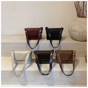 Five assorted minimalist square shoulder bags in rich retro colors on stone steps