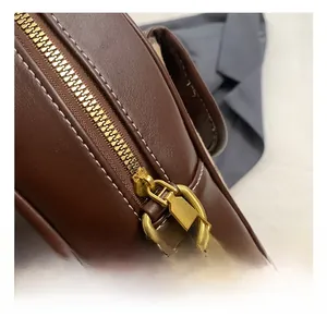 Detail of vintage brown leather backpack showing matte gold zippers and fine stitching