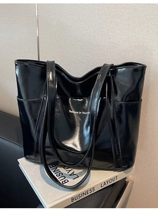 Polished black tote bag with white lettering and side pockets for daily commute
