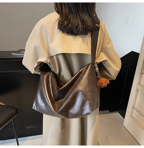 Détail du grand sac cabas en similicuir marron avec large bandoulière et pendentif ours