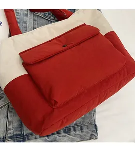 Detail of red and cream canvas tote showing soft fabric texture and buttoned front pocket