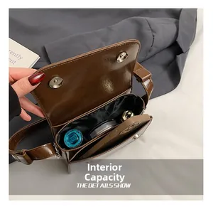 Internal view of brown leather crossbody bag showing capacity for phone and cosmetics