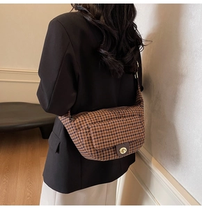 Detailed back view of a vintage brown checkered quilted chest bag on a female model