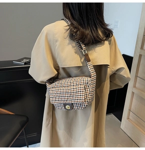Detail of tweed houndstooth crossbody bag with gold metal twist lock and wide strap