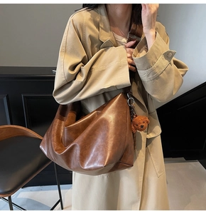Sac cabas en cuir marron avec large bandoulière et accessoire d'ours en peluche doux