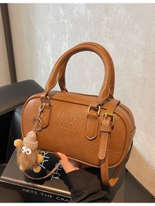 Vintage brown bowling handbag with ATN lettering and cute plush monster pendant charm