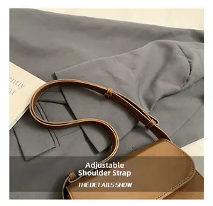 Detail showing adjustable brown faux leather shoulder strap with matching stitching