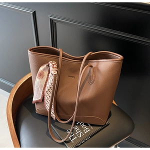 Close-up of brown leather tote bag with WKRO logo and decorative floral scarf