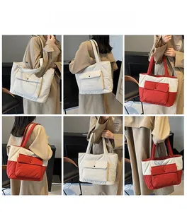 Detail of quilted nylon tote bag showing front flap pocket and soft padded texture