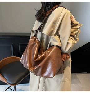 Détail du grand sac cabas marron foncé avec texture plissée et charmant pendentif ours en peluche