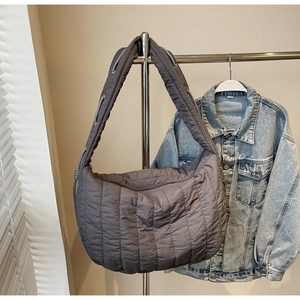 Detail of dark gray quilted tote bag with wide adjustable drawstring shoulder strap
